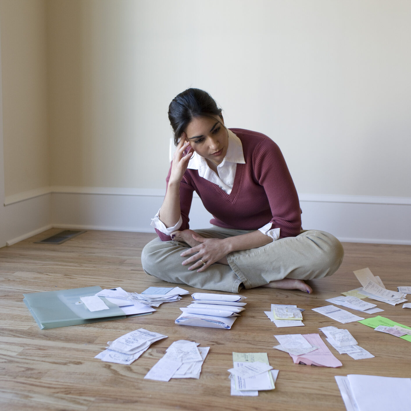 frustrated woman looking at her bills in the floor