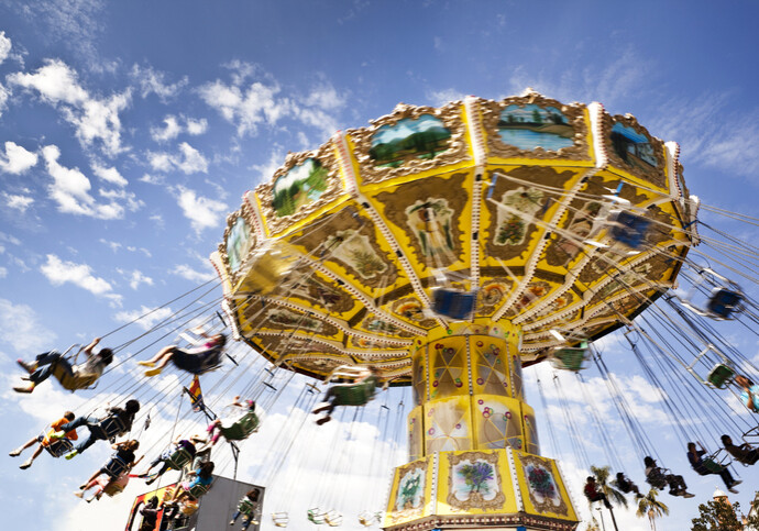 A carnival ride with swings in motion on a cloudy day