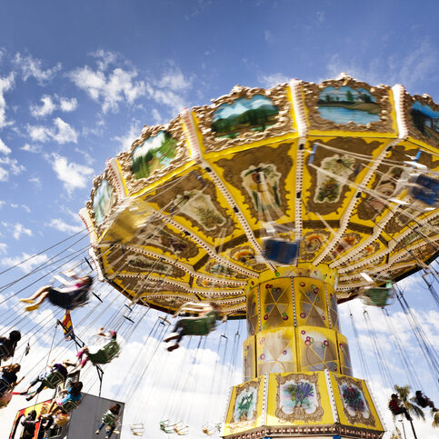 A carnival ride with swings in motion on a cloudy day