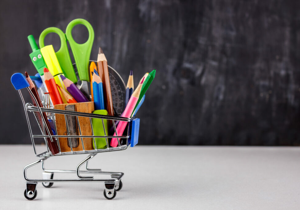 Set of colored pencils and markers for school. Stationery for the student - scissors, sharpener, eraser in a shopping cart