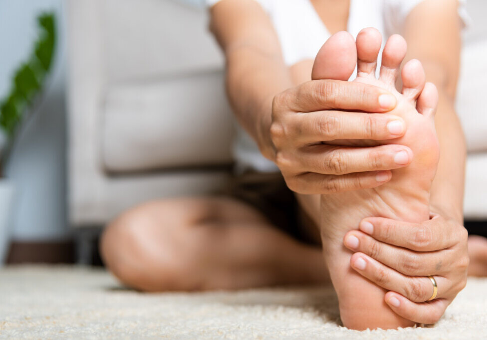 Asian woman feeling pain in her foot at home
